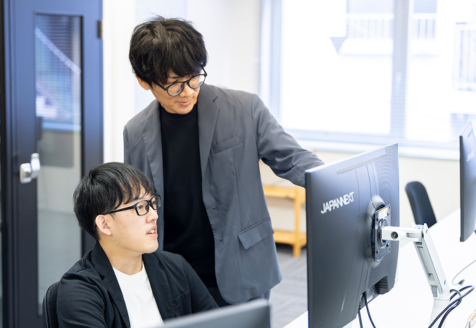社員同士でコミュニケーションをとり、協力している3名の社員